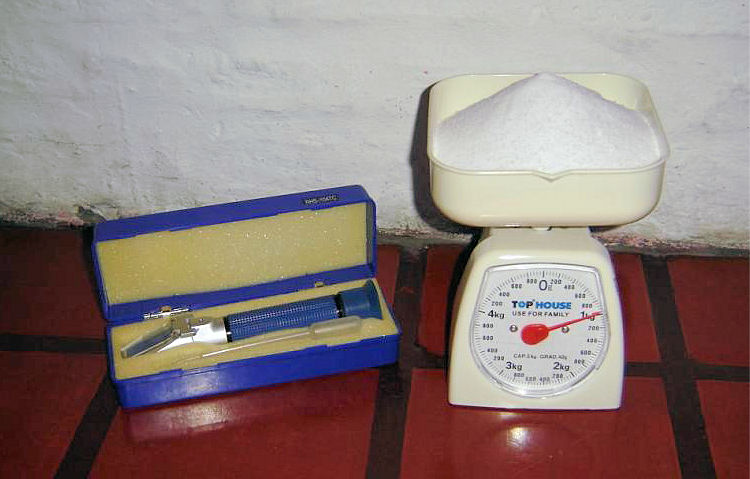 Refractómetro, balanza y sal, utilizados para preparar agua para un acuario marino.